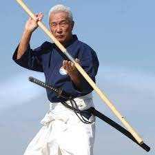 la photo représente le Soke maître Hiroo Mochizuki tenant un baton, le bô en japonais.